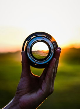 a-person-holding-a-camera-lens-in-their-hand.jpg a person holding a camera lens in their hand