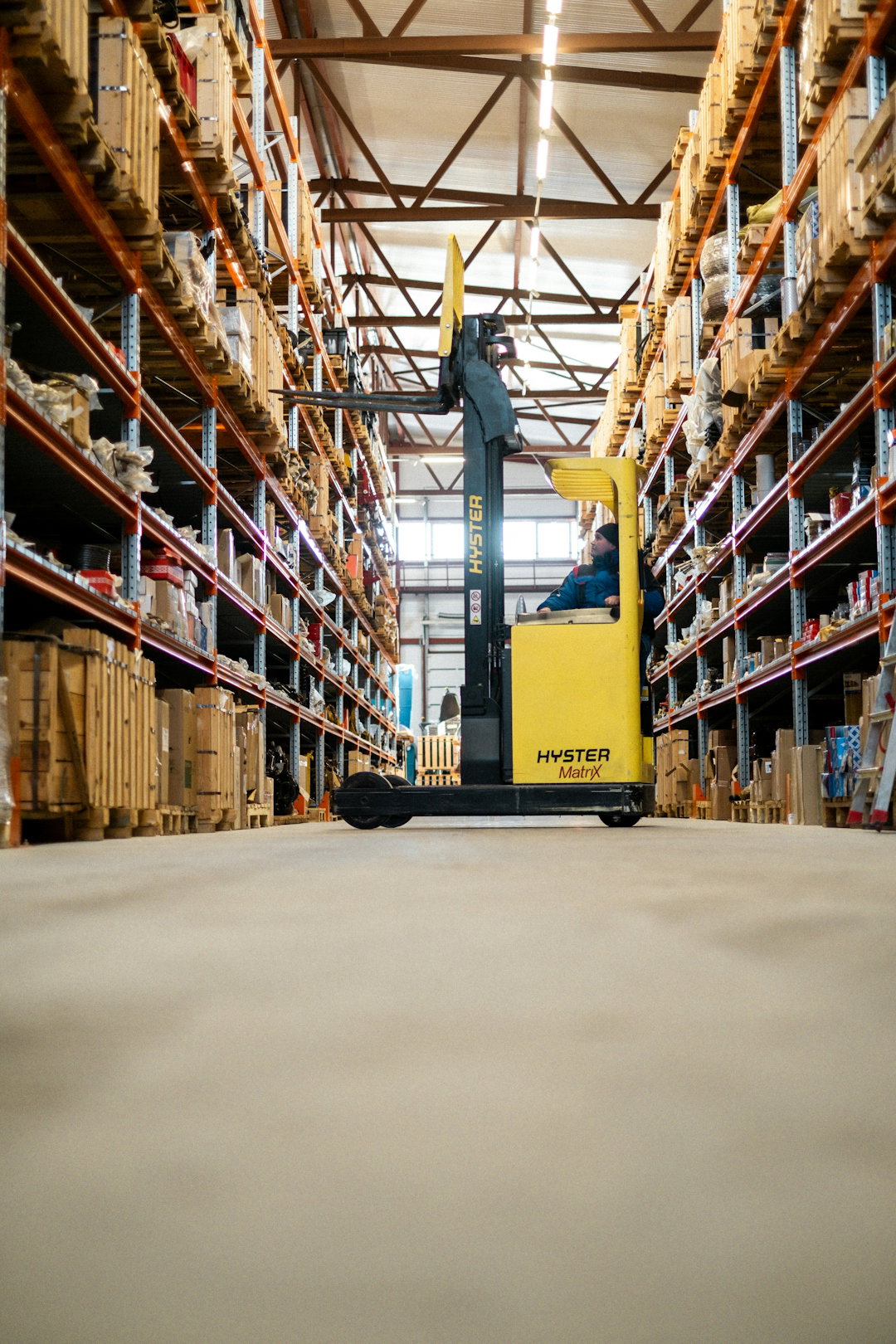 a-yellow-forklift-in-a-large-warehouse.jpg Uma empilhadeira amarela em um grande armazém.
