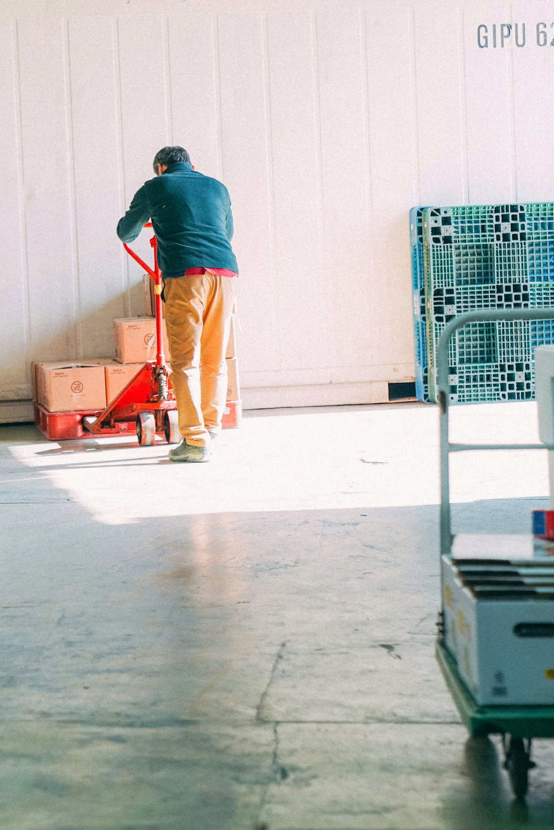 a-man-standing-next-to-a-red-cart-in-a-garage.jpg um homem em pé ao lado de um carrinho vermelho em uma garagem